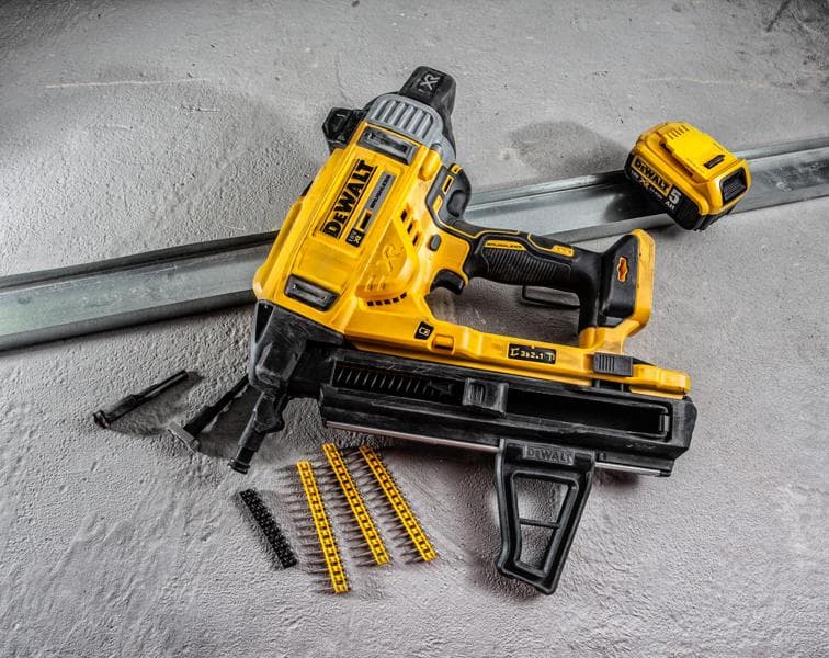 Cloueur à batterie DEWALT DCN890P2 avec accessoires et fixations sur surface béton.